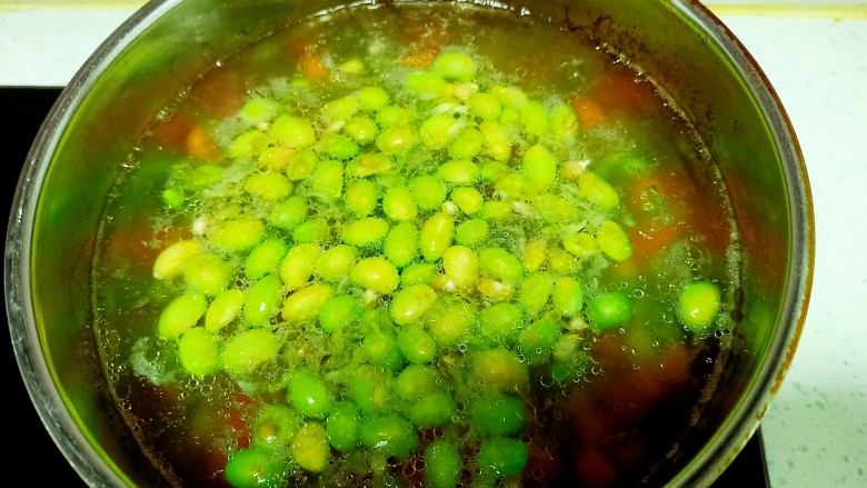 毛豆炒鸡丁,锅中放入适量水,水开后放入几滴油,少许盐,放入毛豆,胡萝卜,土豆,玉米粒