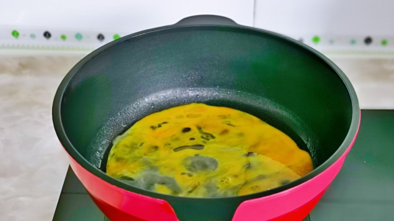 金针菇炒蛋,起油锅,倒入蛋液,小火煎蛋。