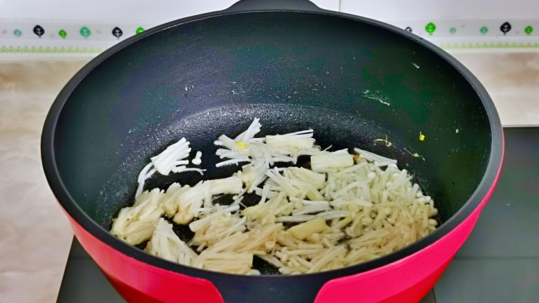 金针菇炒蛋,起油锅,加入切好的金针翻炒。
