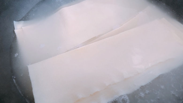 豆皮金针菇卷,锅内烧开水,把豆皮放入水里焯水。