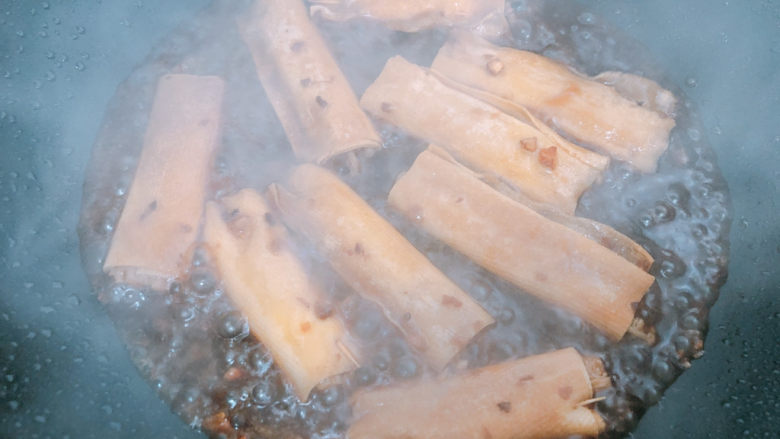 豆皮金针菇卷,倒入锅中,等待收汁。