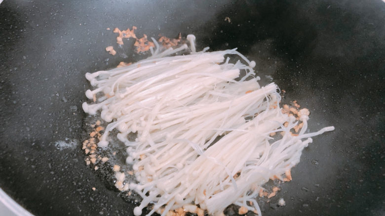 金针菇炒蛋,锅内热油放入蒜末爆香,加入金针菇。