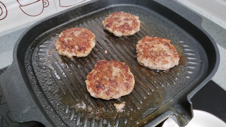 美式汉堡Simple Burger,大火加热烤盘，喷点油(没有烤盘用普通铁锅/不粘锅也可以)依你捏的厚度煎熟(冷冻肉最好还是吃熟一点)，我的单面煎了两分钟。加锅盖煎比较不会干掉。