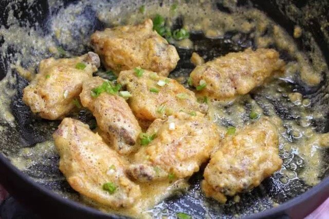 蛋黄焗鸡翅,然后放入炸好的鸡翅中,翻炒均匀裹上蛋黄,出锅前加入切碎的<a style='color:red;display:inline-block;' href='/shicai/ 3232'>香葱</a>即可。