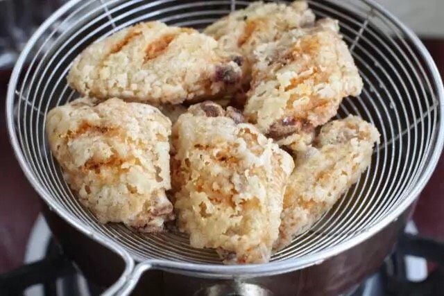 蛋黄焗鸡翅,炸至鸡翅定型变色后捞出沥油,稍微晾凉后再次升高油温,放入鸡翅大火复炸半分钟左右,表层金黄酥脆捞出控油。