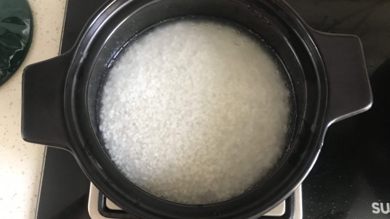香菇滑鸡煲仔饭,加入适量的水,大火烧开煮咕噜冒泡,水分快干