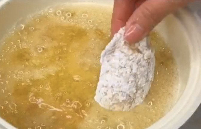 蛋黄焗鸡翅,裹好粉的鸡翅下锅炸,油温六层热下锅满炸