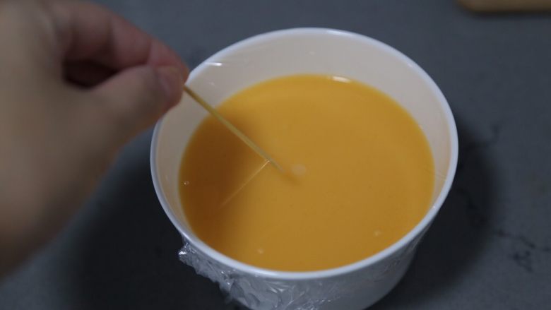 肉末蒸蛋羹,将过滤好的蛋液改善保鲜膜,并用牙签刺几个小孔