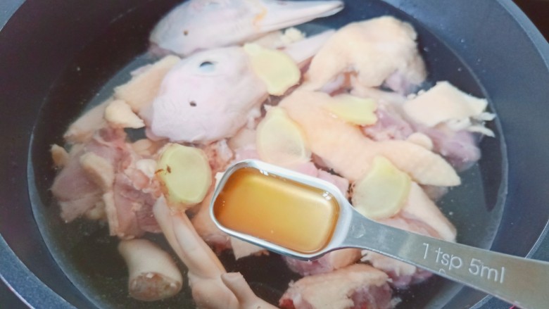 鸭翅炖土豆,锅里加适量的清水,放入鸭块,生姜片与料酒。