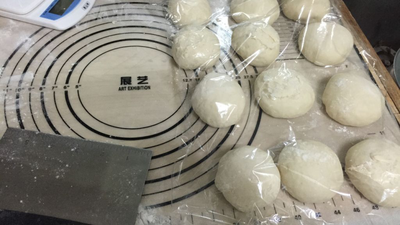 葱花发面饼,将面放在案板上,按压排气分成12个面团揉圆,静置松弛10分钟;