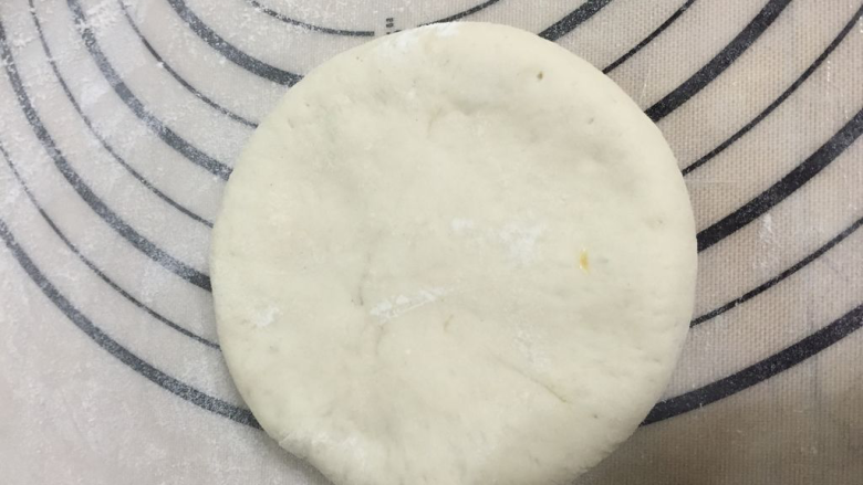 葱花发面饼,案板撒上薄面,避免粘,将面团收口冲上;