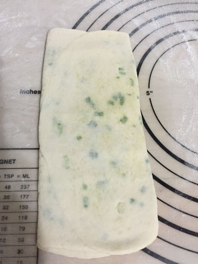 葱花发面饼,再次擀平,上下往中间折,这是第二次三折;
