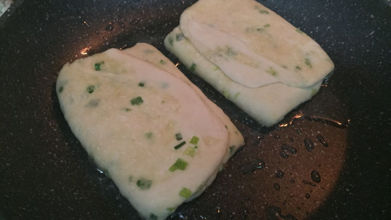 葱花发面饼,之后将面饼稍稍擀平一下，因为静置它会发起来，放入平底锅中 每面大概烙2-3分钟就可以翻面了；