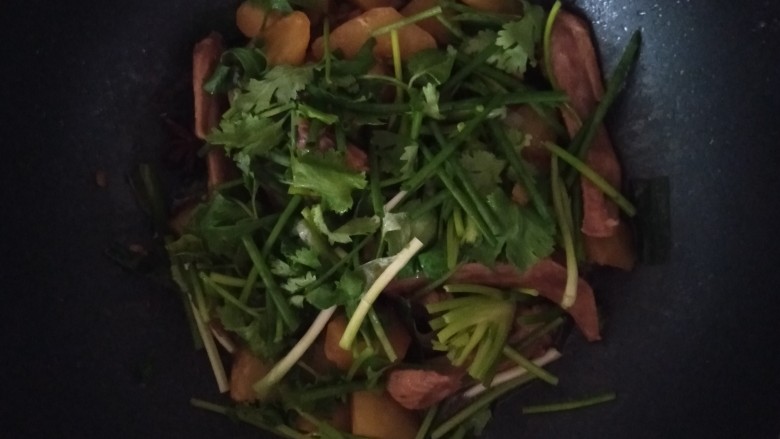 鸭翅炖土豆,还有一点汁的时候加入香菜和葱翻炒均匀,香菜和葱熟了就出锅