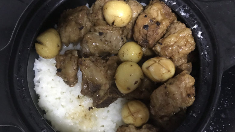 豉汁排骨煲仔饭,米饭煮至呼噜呼噜冒泡时,把排骨和鹌鹑蛋放在上面,边上淋入玉米油,小火焖煮6分钟