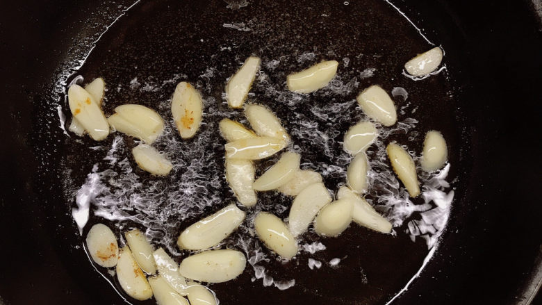 青椒肉片,热锅冷油放入蒜片炸出香味。