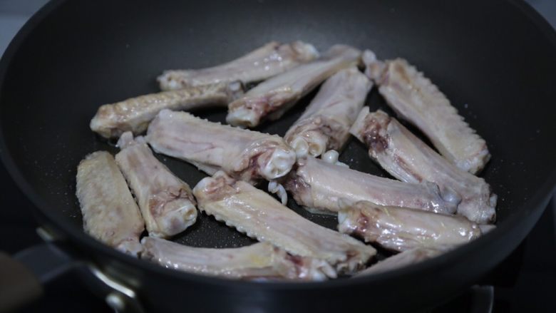 鸭翅炖土豆,锅里倒入少许油,烧热后放鸭翅煎制