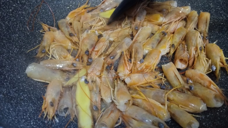 鲜虾瑶柱粥,锅里放油烧热加入姜片虾头爆炒,然后加入水,煮虾头三分钟后把虾头和虾水一起倒入洗干净的米中。开始煲粥。
把干货也一起放入锅中煲