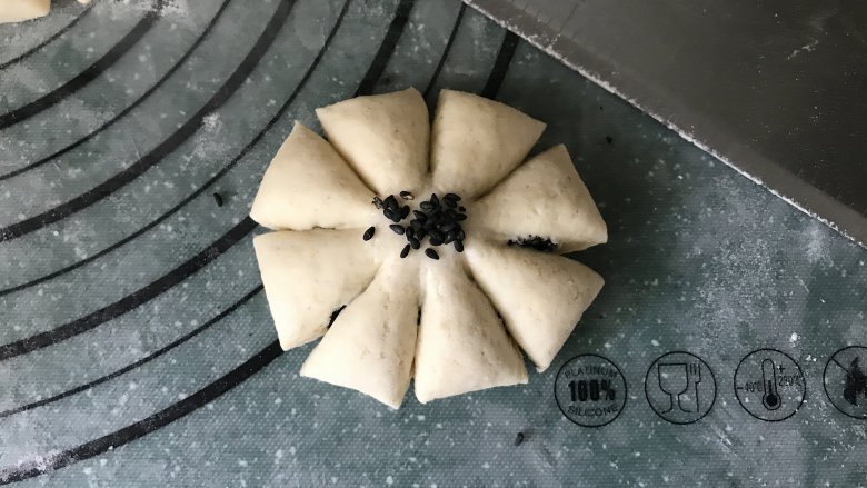 花朵馒头,在中间刷清水,放上黑芝麻;简单又漂亮的花朵黑芝麻馒头生胚就做好了