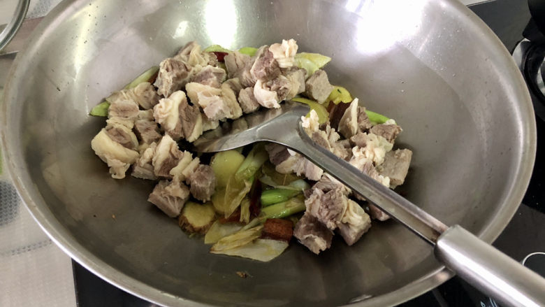 胡萝卜炖牛腩,转中火,加入牛腩,不断翻炒一分钟