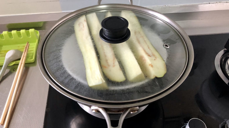 蒜蓉茄子,蒸锅烧水,放入茄子,水开蒸10到15分钟,到筷子可以轻松戳进茄子,即可关火
