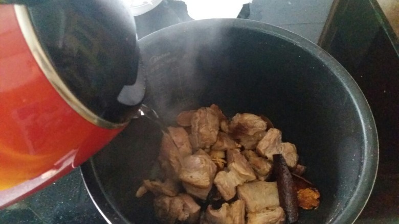 胡萝卜焖牛腩,放入电饭煲中,加开水,记得是开水,不能是冷水,开水尽量一次性加足,避免中途加水,如果中途要加水也必须是热水。