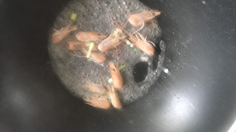 金针菇豆腐汤,起锅热油,下入葱白和虾头炒香