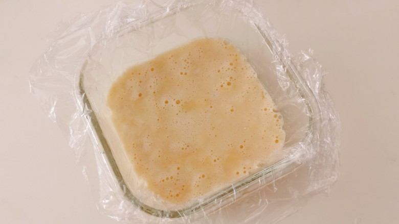 山药鸡蛋糕,玻璃器皿中铺上保鲜膜,倒入山药鸡蛋糊。