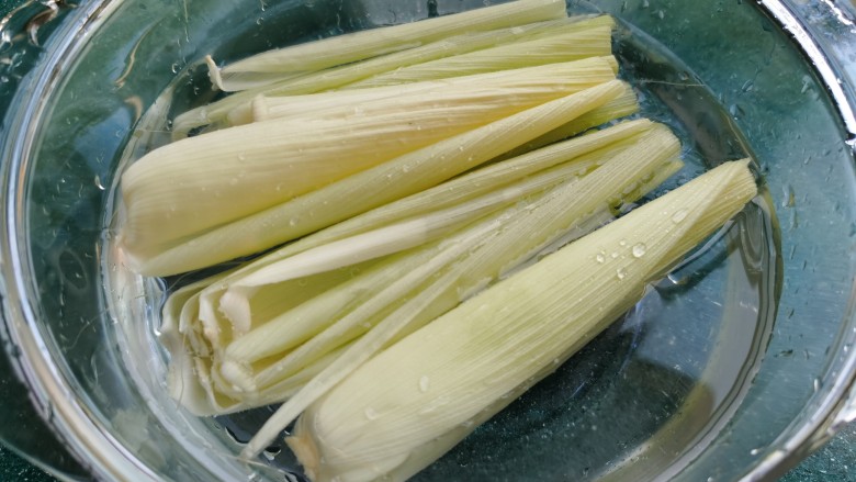 黄金玉米饼,玉米叶子也冲洗干净,剪掉叶子两头不平整和较窄的地方,留取中间平整较宽的部分。