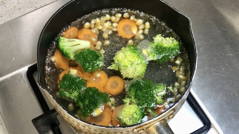 五彩缤纷的杂蔬芝士饭团 ，孩子超喜欢！,把西兰花切小朵，胡萝卜切成片，和玉米粒一起放入沸水中焯熟。