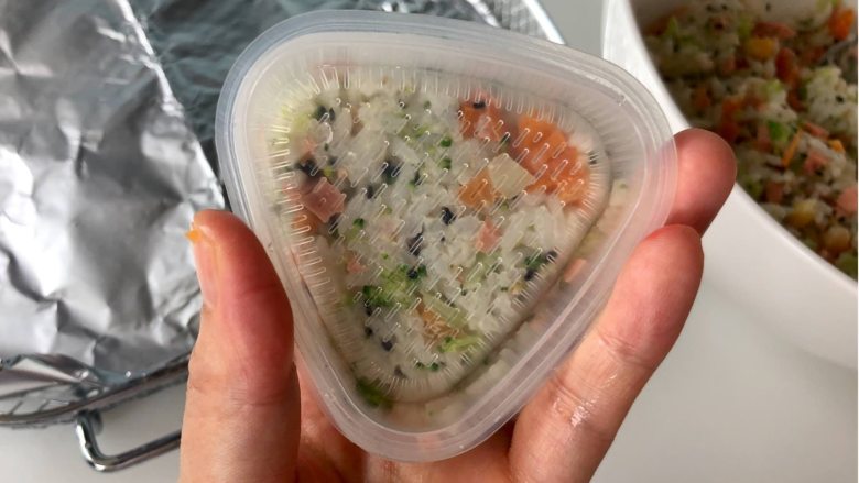 五彩缤纷的杂蔬芝士饭团 ，孩子超喜欢！,把拌好的米饭装入三角饭团模具，用力压好，避免散开。如果没有模具，也可以用保鲜膜裹好饭团。