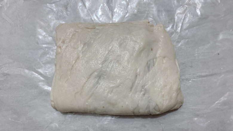 红豆派,软化后的手抓饼皮,有延展性,将其对折,轻轻压扁平。