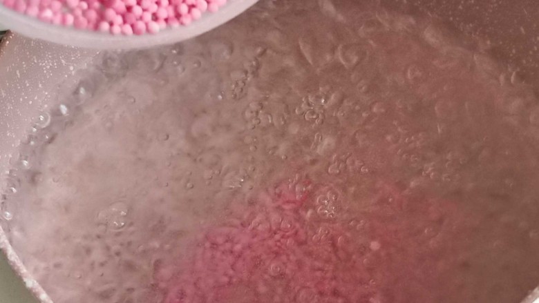 缤纷水果西米露,起锅烧水,水开后倒入粉色草莓味西米,中到大火煮15分钟。普通白色的西米也可以