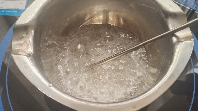 艾素糖造型水果蛋糕,巧克力锅中倒入艾素糖和清水,不要搅拌,小火慢慢加热到170-175度左右关火。加入一滴蓝色色素,用牙签搅一搅