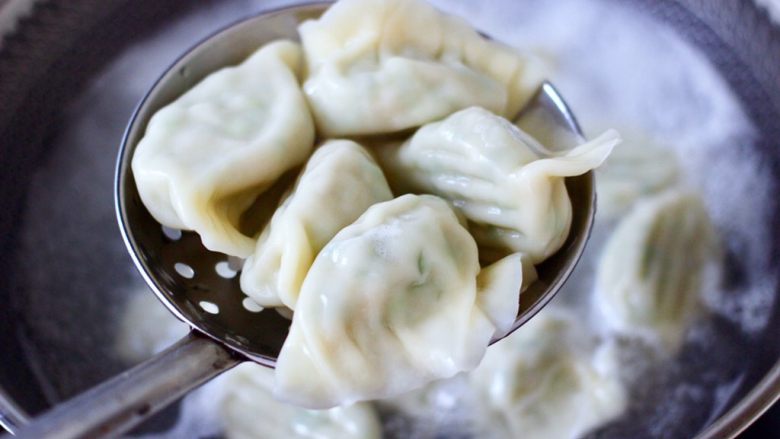 烟台正宗鲅鱼饺子,把煮好的鱼饺子捞出沥干水分,盛到盘子里面。