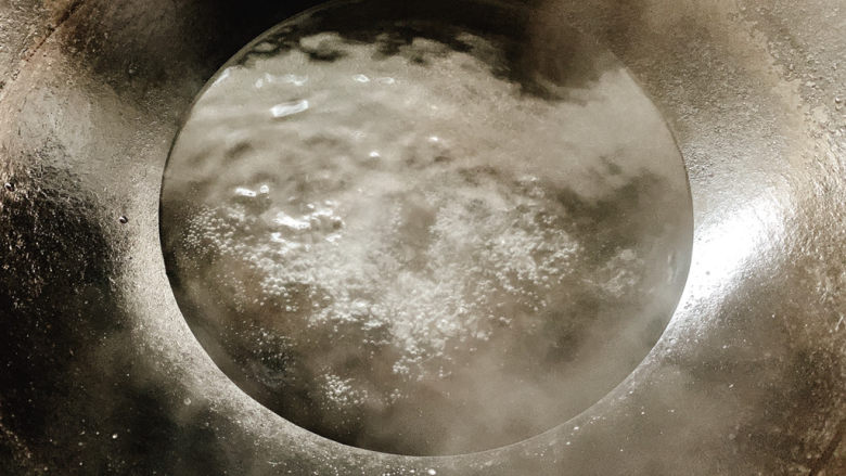 韭菜炒鸭血,锅中烧水,沸腾后加入少许盐。