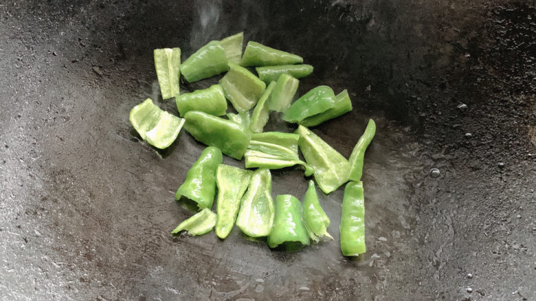 青椒炒香肠,旺火将青椒放入爆香,炒出呛辣香味。