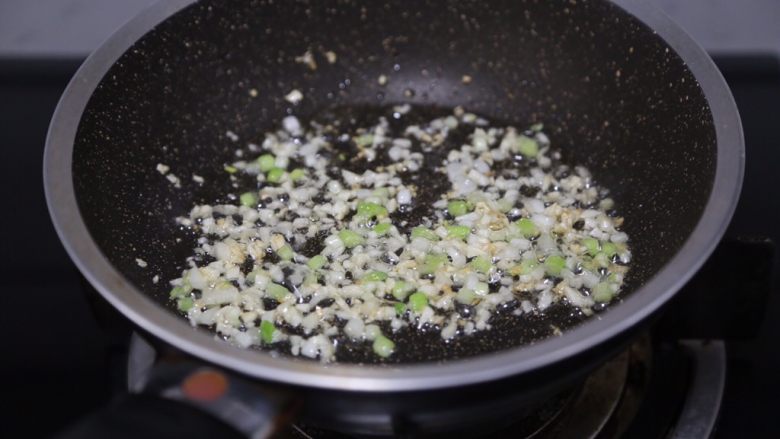 金针菇豆腐汤,锅里烧热油,爆香蒜末和葱白