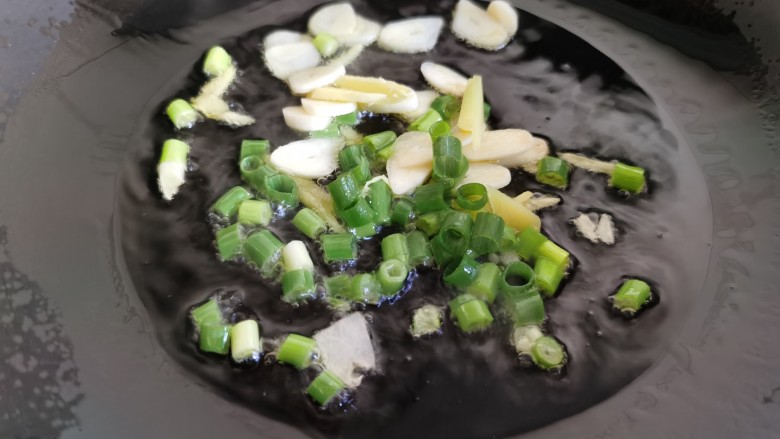 金针菇豆腐汤,锅里加油烧热,放入葱、姜、蒜爆锅。