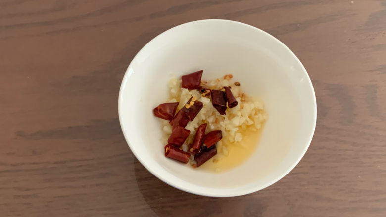 黄瓜拌腐竹,炸好的辣椒油趁热倒入装有蒜末的碗,激发蒜味的香气