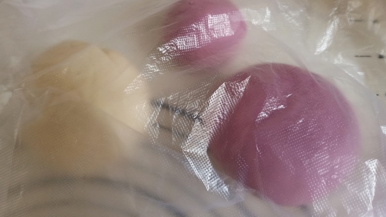 紫薯小馒头,将紫薯面团取200克出来,分成大小两个部分,150克和50克,揉成圆球状。盖上塑料袋或盖子醒十分钟