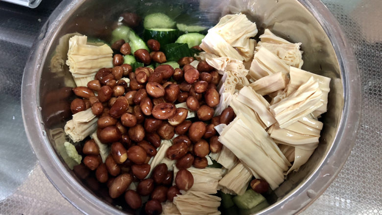 黄瓜拌腐竹,取一个深盆,方便搅拌,加入黄瓜,炸花生米,腐竹