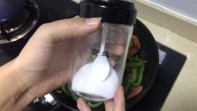 青椒炒香肠,青椒翻炒变软后加入食盐少许