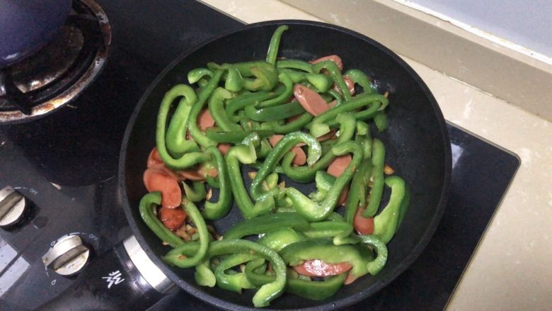 青椒炒香肠,煸炒一会后加入青椒