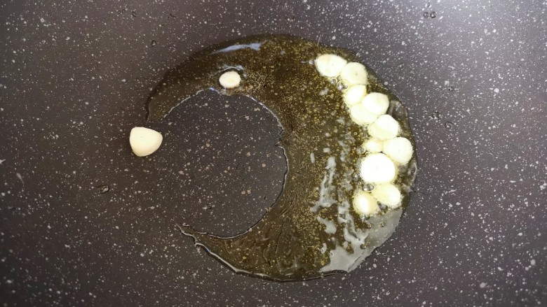 毛豆炒香干,炒锅内倒适量的食用油烧热,下入蒜片炒香。