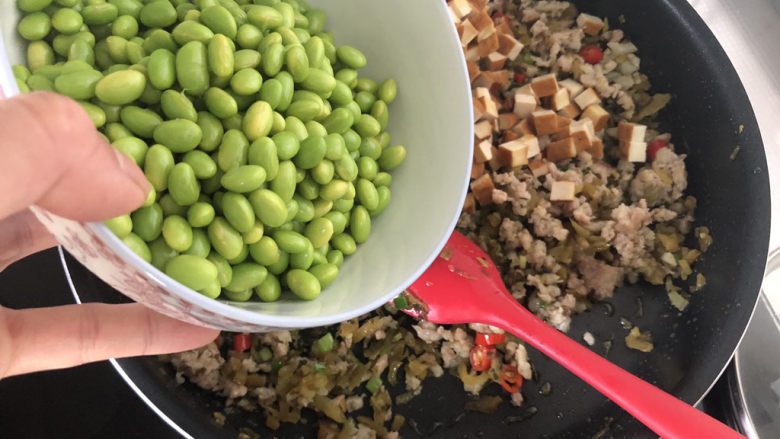 毛豆炒香干,加入毛豆米,中火翻炒一分钟