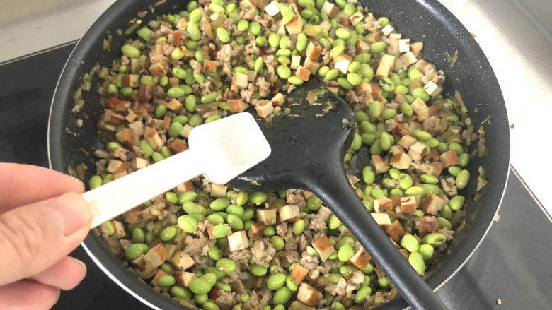 毛豆炒香干,尝下咸淡,根据个人口味添加少许食盐翻炒均匀出锅