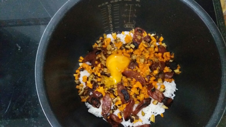 电饭煲腊肠饭,磕蛋,加一点点可饮用水,不然放进电饭煲焖的时候会好干