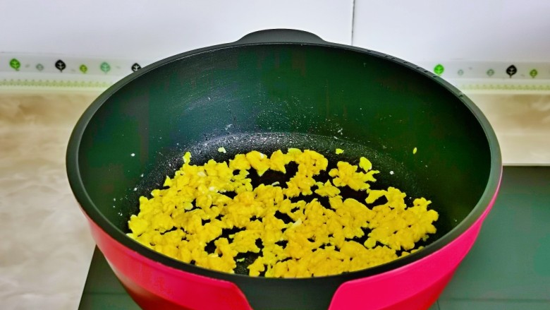 酱油蛋炒饭,起油锅,倒入蛋液,立即用筷子不停搅拌,煎至蛋液凝固盛出备用。