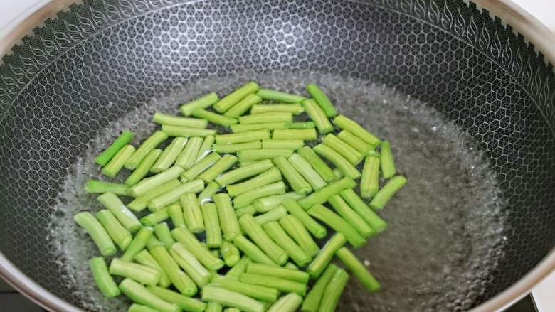 爆炒章鱼,长豇豆焯水,滴几滴食用油大火煮2分钟,捞出过凉水。